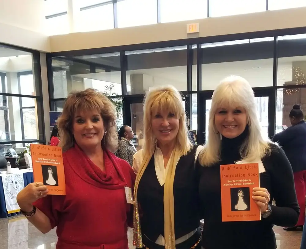 Diana Jordan with two fans holding copies of her book