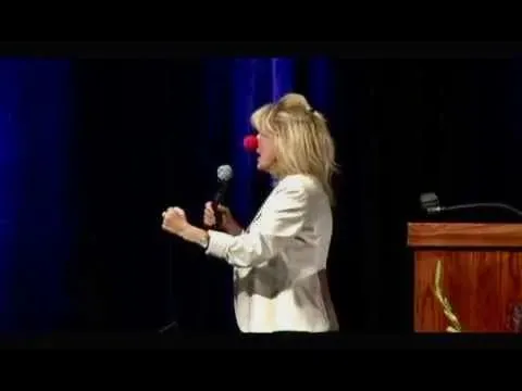 Diana Jordan on stage wearing a red clown nose during a healthcare keynote